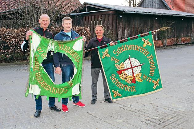 Stolz auf die neue Fahne, in die ein Symbol aus der alten Fahne eingepasst ist, sind Vorsitzender Karl-Heinz Suttrup, Stellvertreter Wolfgang Hooghoff und Fahnenträger Tönne Tertilt. Von der alten Königskette (kl. Foto) sind nur noch einige Teile vorhanden, die Schützenkönige tragen ein neues Exemplar. Foto: hko